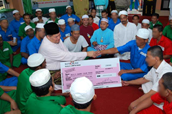 Ustaz Hasbullah menunjukkan Replika Cek yang diterima hasil kutipan zakat daripada penghuni